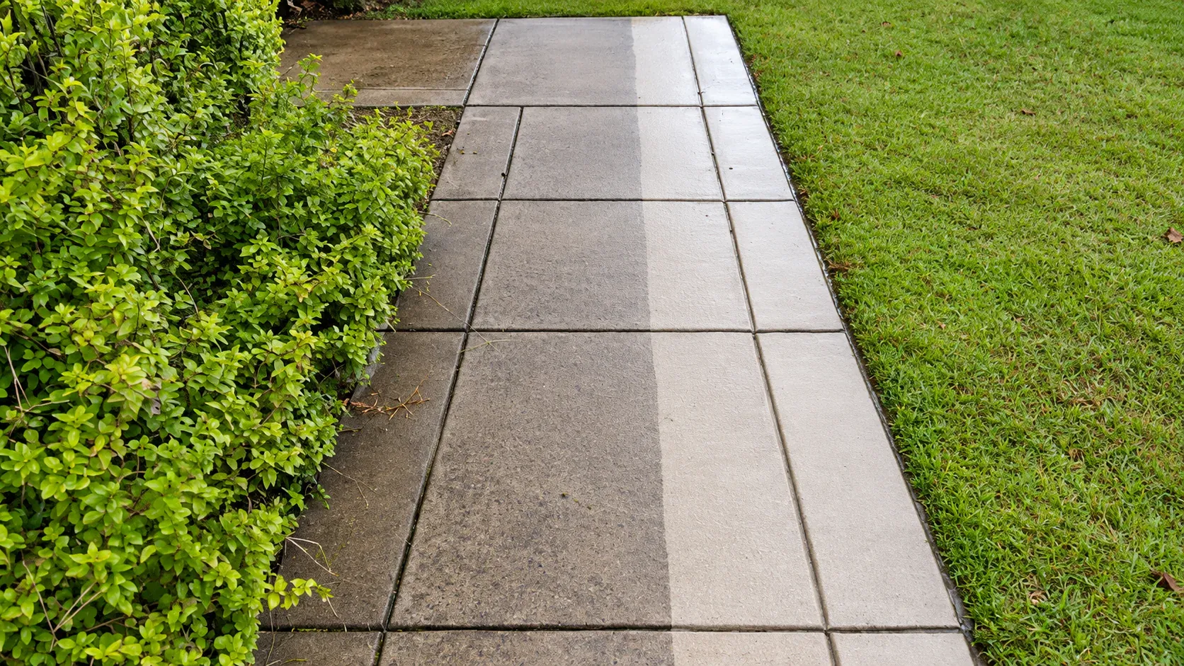 Concrete walkway beside a lawn, with part of the concrete cleaned lighter